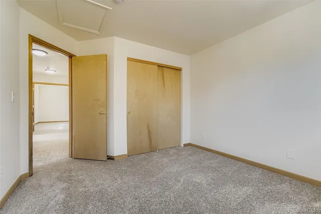 an empty room with windows and closet
