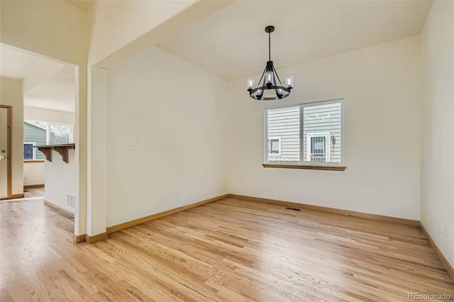 a view of empty room with wooden floor and ceiling fan