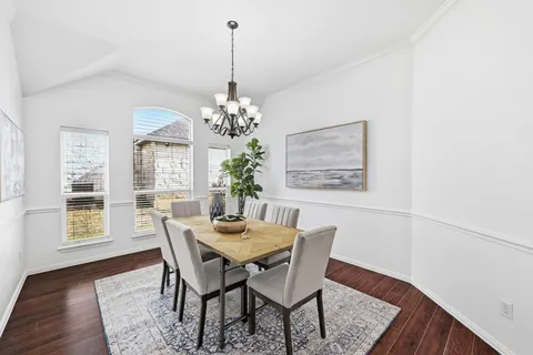 a view of a dining room with furniture wooden floor and a chandelier