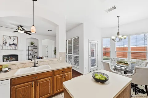 a kitchen with stainless steel appliances a sink a table and chairs