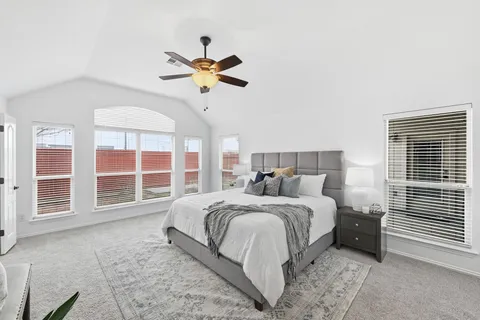 a bedroom with a large bed and a chandelier