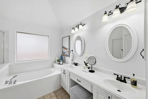 a bathroom with a tub sink and mirror
