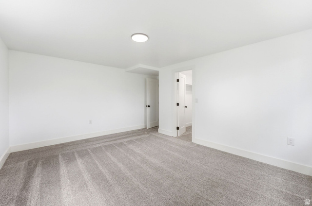 871 Bonita Way Centerville, UT 84014 - Photo 34 of 61 Spacious room featuring light gray carpet, white walls, white baseboards, a flush-mount ceiling light fixture, and a white door with black hardware
