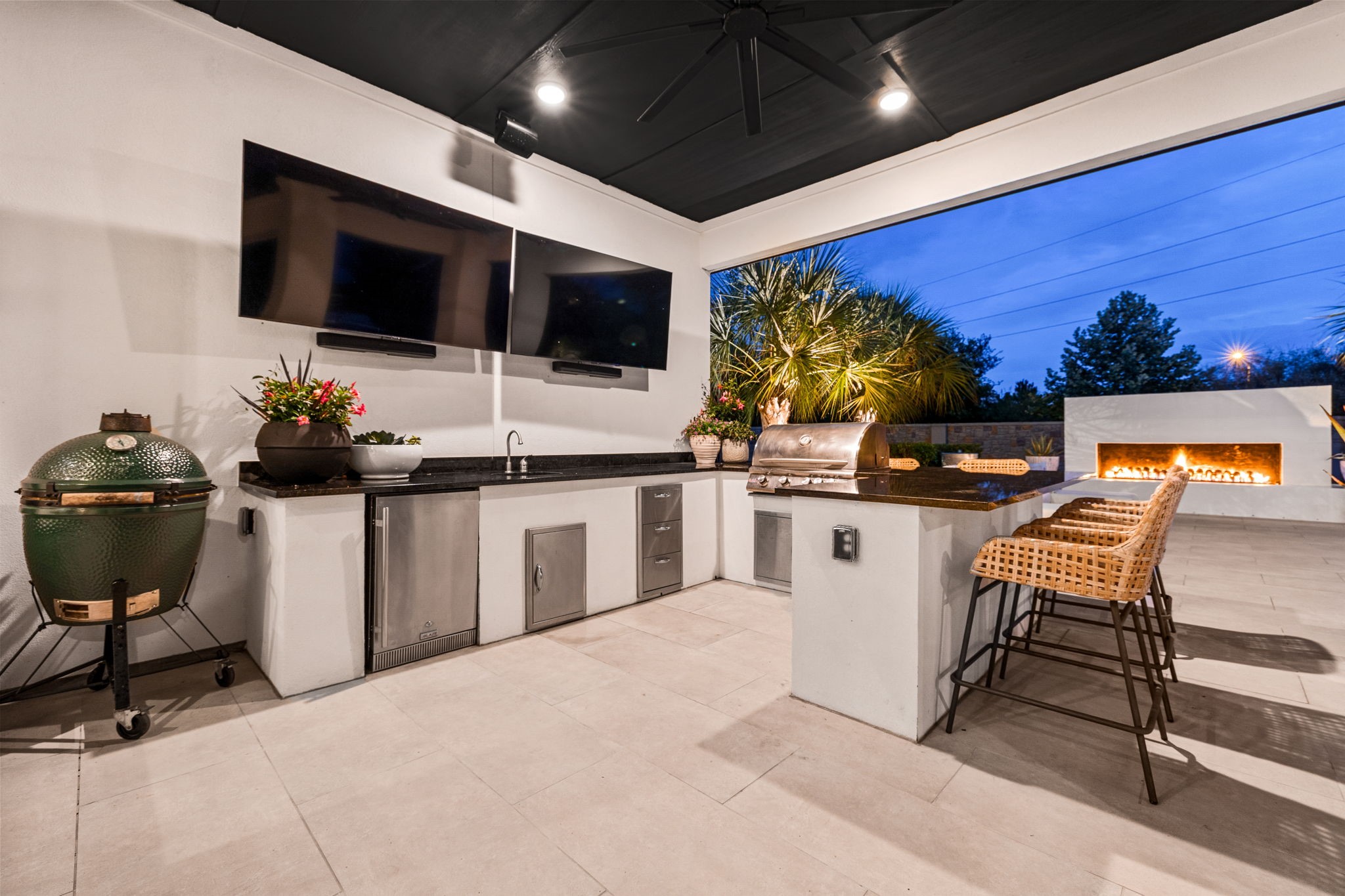 27903 Indigo Ridge Drive Fulshear, TX 77441 - Photo 41 of 50 Fully equipped outdoor kitchen featuring dual TVs, premium grilling stations, and bar seating overlooking the pool.