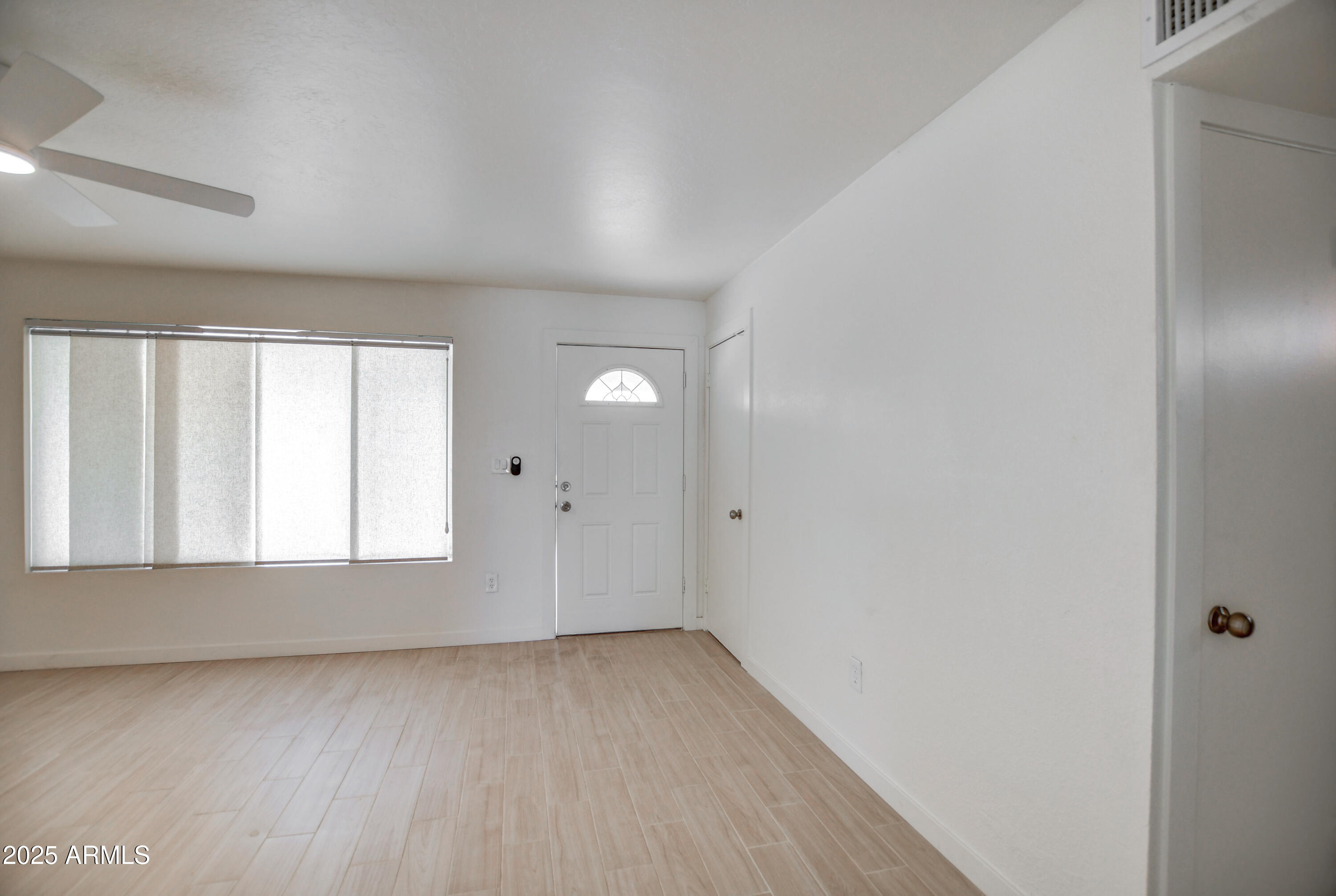 4870 West Almeria Road Phoenix, AZ 85035 - Photo 4 of 22 an empty room with wooden floor and windows
