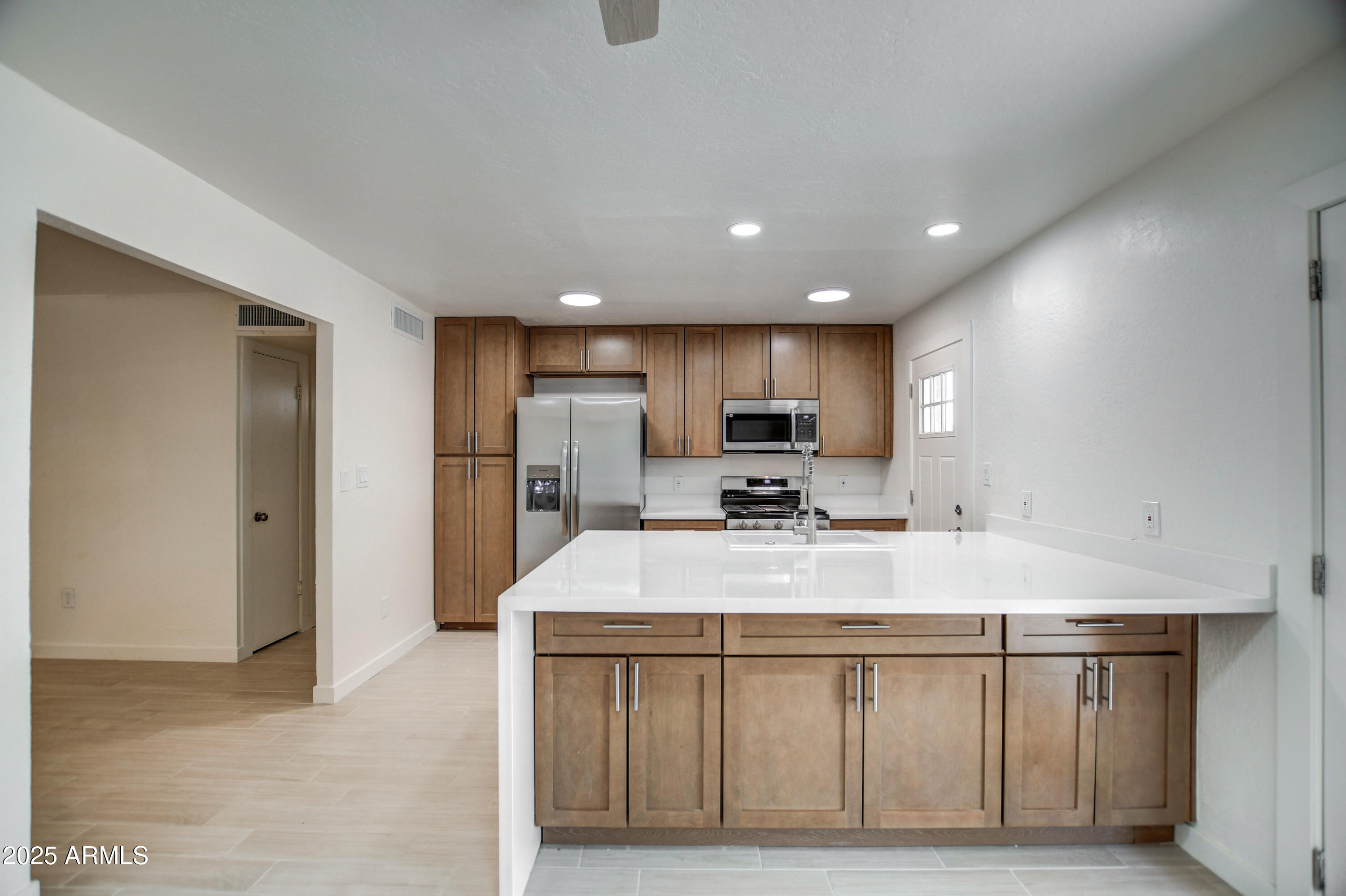 4870 West Almeria Road Phoenix, AZ 85035 - Photo 5 of 22 a kitchen with stainless steel appliances a sink stove refrigerator and cabinets