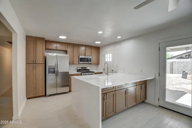 a kitchen with a sink a refrigerator and a stove top oven