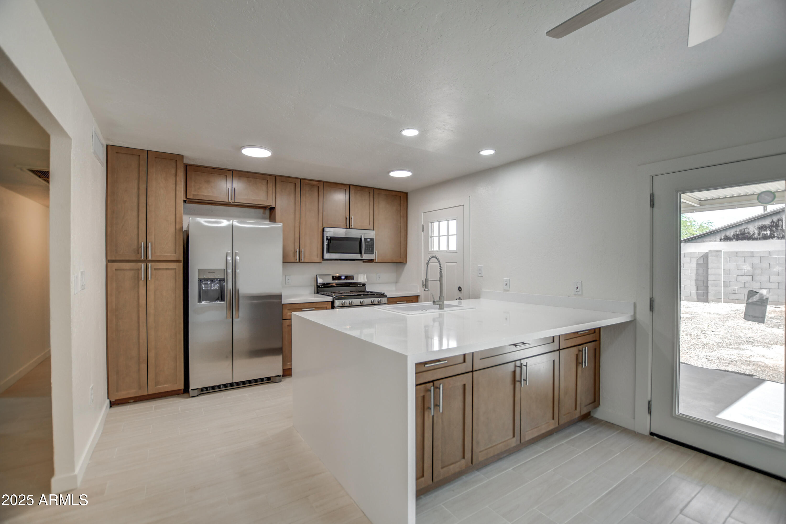 4870 West Almeria Road Phoenix, AZ 85035 - Photo 6 of 22 a kitchen with a sink a refrigerator and a stove top oven