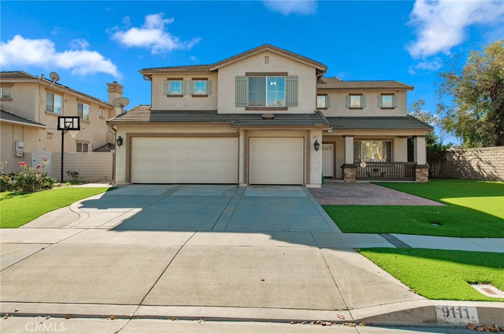 9111 Hamilton Street Rancho Cucamonga, CA 91701 - Photo 2 of 46 a front view of a house with a yard