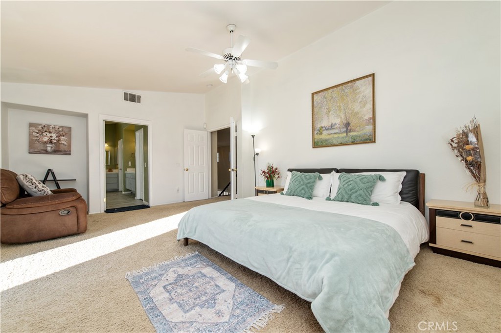 9111 Hamilton Street Rancho Cucamonga, CA 91701 - Photo 28 of 46 a spacious bedroom with a large bed and a chandelier