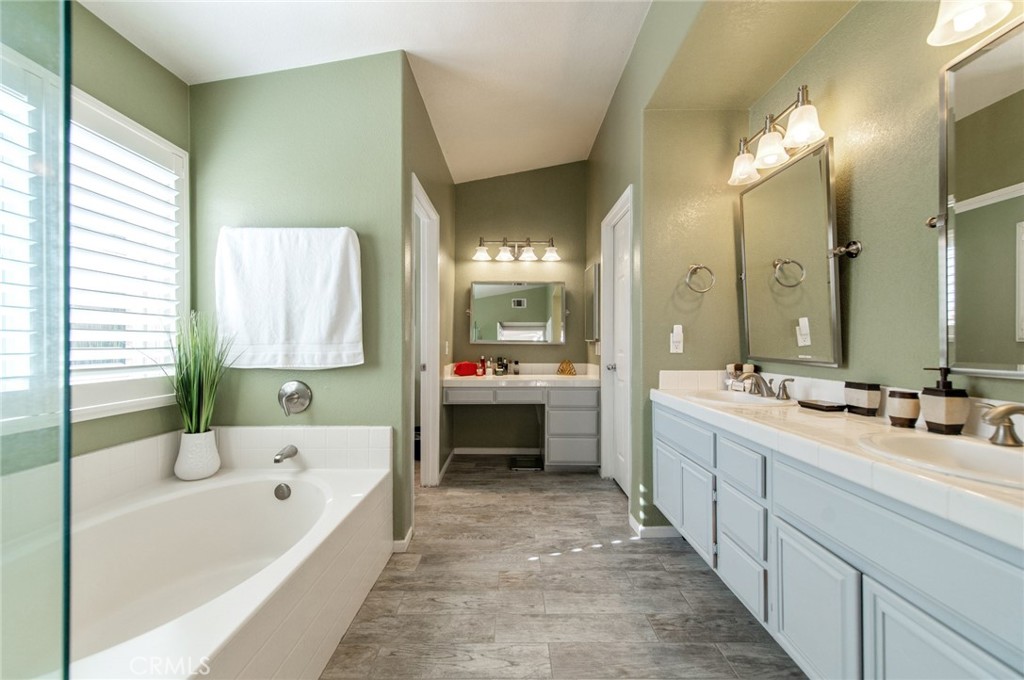 9111 Hamilton Street Rancho Cucamonga, CA 91701 - Photo 29 of 46 a bathroom with a tub a double vanity sink and mirror