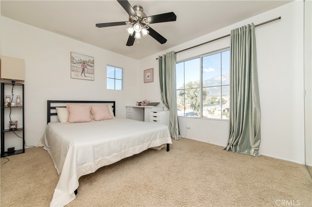 9111 Hamilton Street Rancho Cucamonga, CA 91701 - Photo 33 of 46 a spacious bedroom with a large bed and a chandelier fan