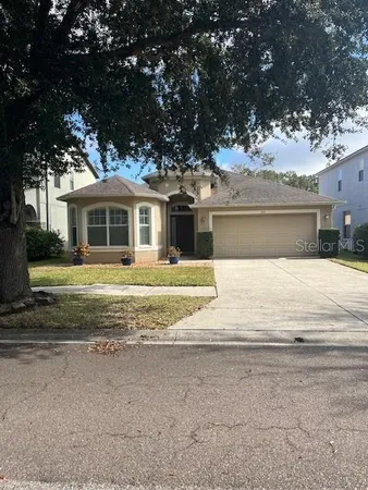 a front view of a house with a yard and trees