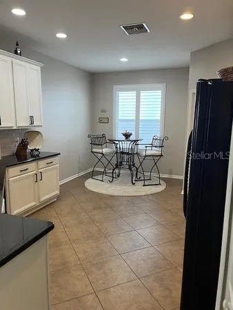 a view of a kitchen with a sink and dishwasher a refrigerator with white cabinets