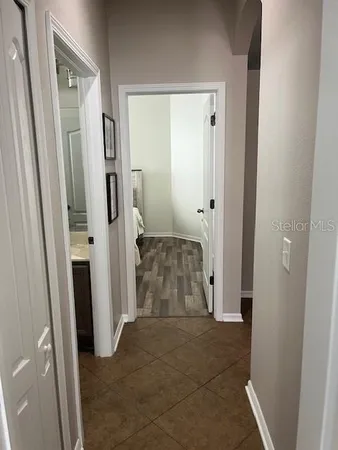 a view of a hallway with wooden floor and a livingroom