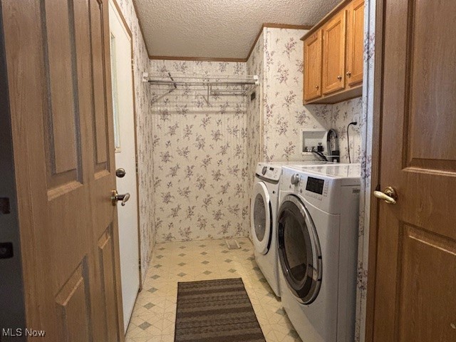 12575 Zane Road Lore City, OH 43755 - Photo 22 of 37 Laundry area with light floors, wallpapered walls, a textured ceiling, washing machine and dryer, and cabinet space