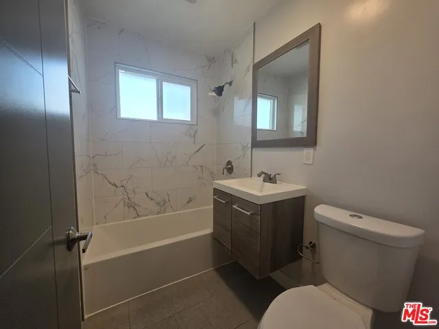 a bathroom with a sink toilet vanity and shower