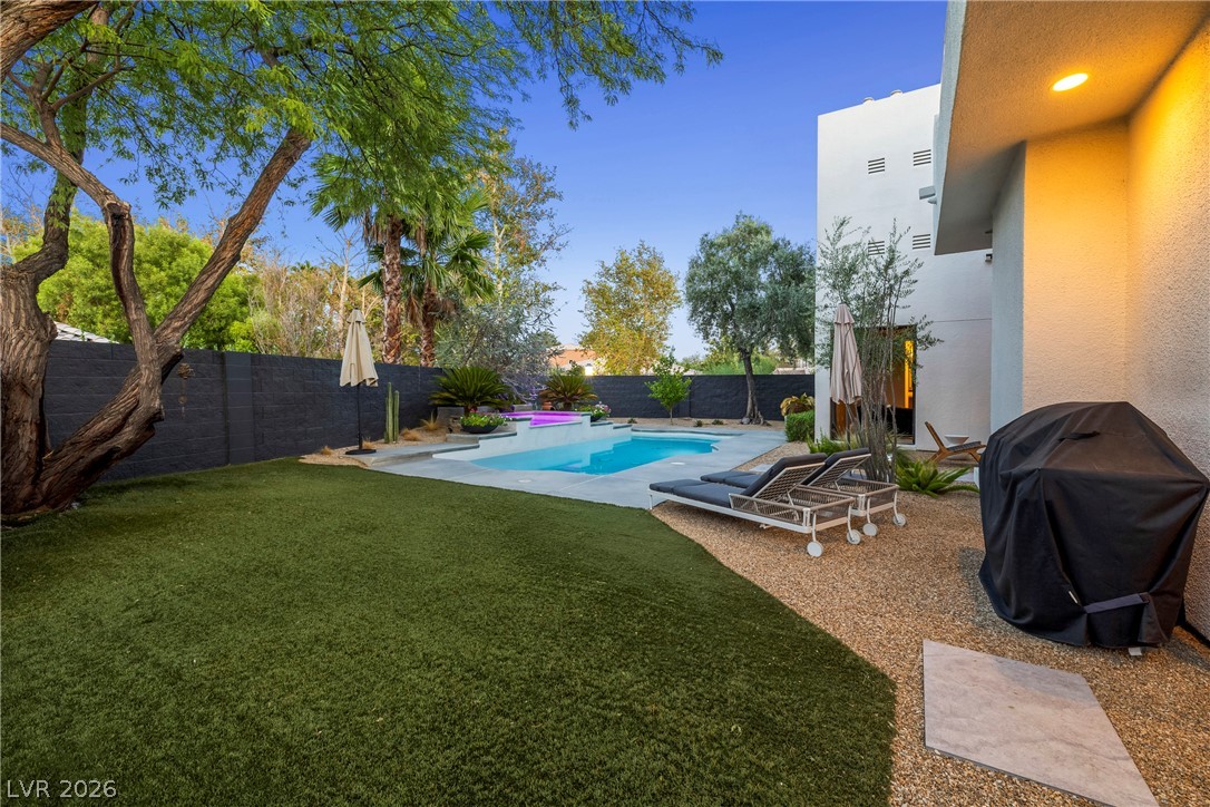 2000 Grouse Street Las Vegas, NV 89134 - Photo 54 of 89 A private backyard oasis features artificial turf and a shimmering swimming pool with a vibrant spa.