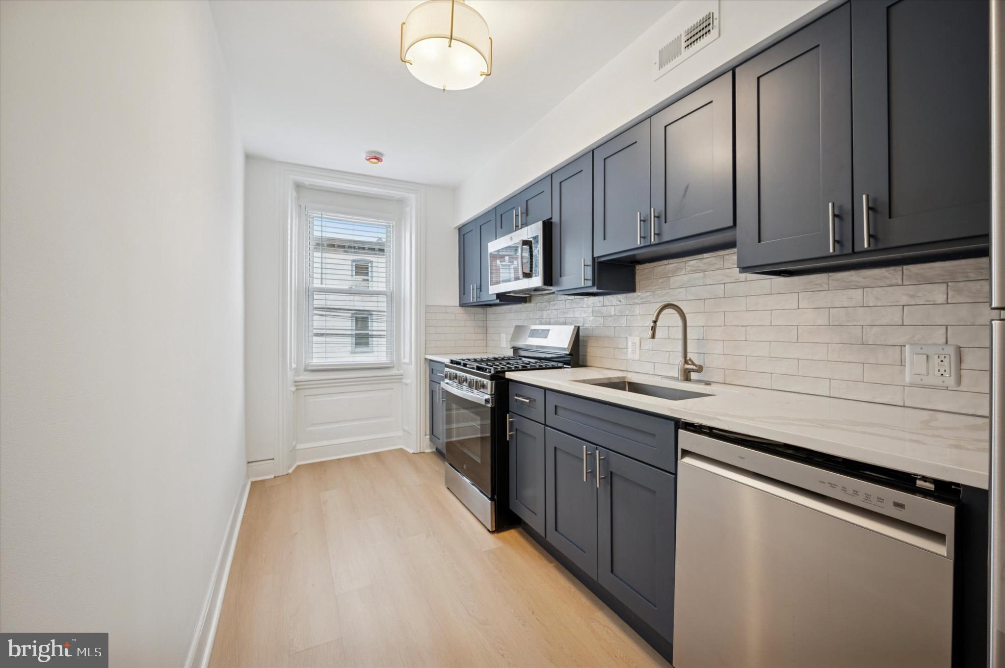3869 Terrace Street, Unit 2 Philadelphia, PA 19128 - Photo 12 of 16 a kitchen with cabinets appliances and a sink