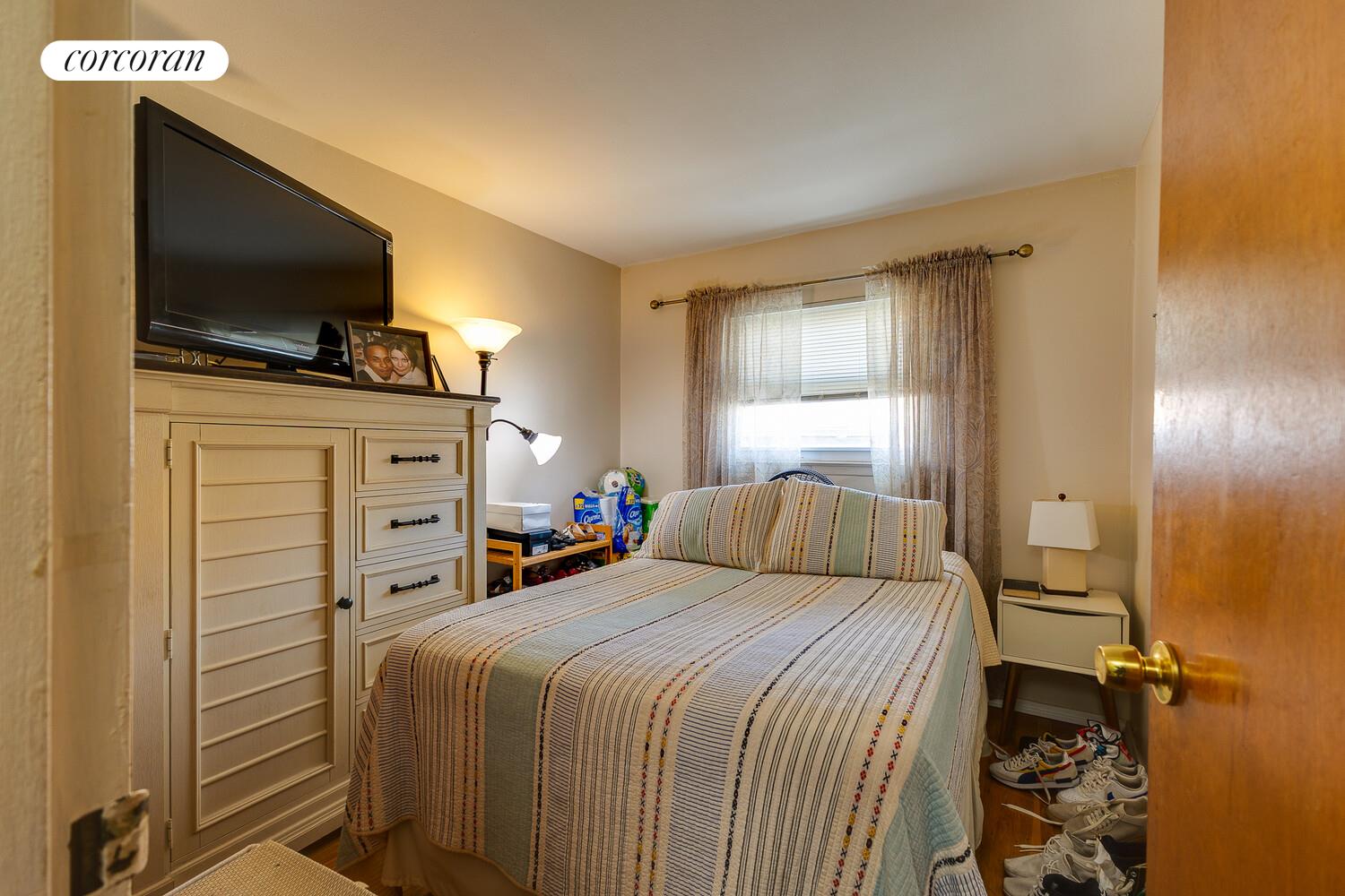 137-17 160th Street Queens, NY 11434 - Photo 11 of 14 a bedroom with a bed and a flat screen tv