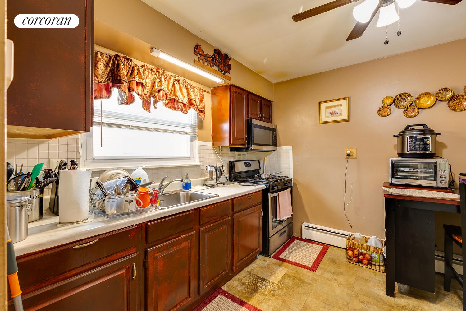 137-17 160th Street Queens, NY 11434 - Photo 14 of 14 a kitchen with stainless steel appliances a sink cabinets and wooden floor