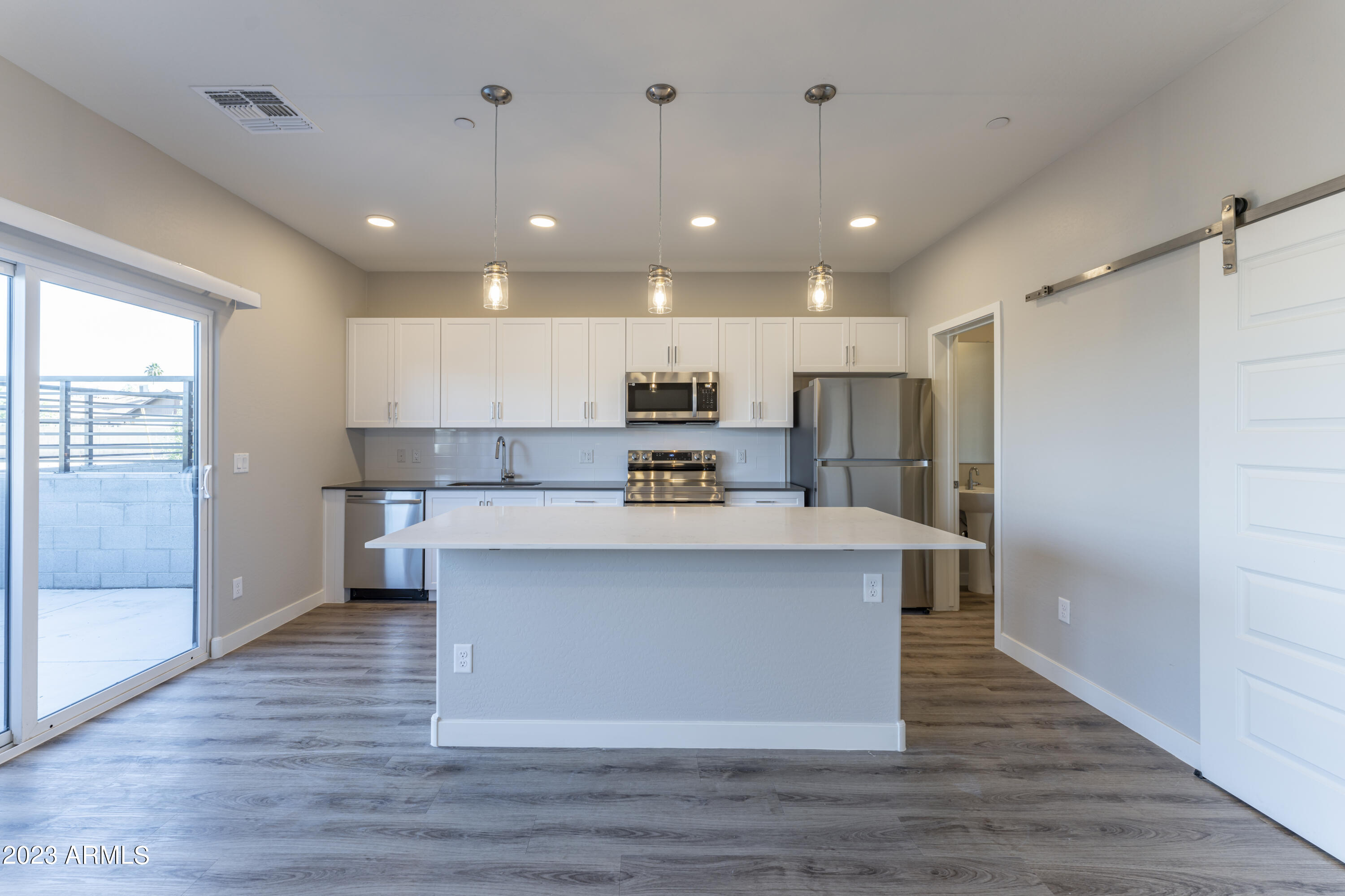 432 South 32nd Street, Unit 104 Mesa, AZ 85204 - Photo 1 of 75 a view of kitchen with stainless steel appliances granite countertop a stove top oven a refrigerator and white cabinets with wooden floors