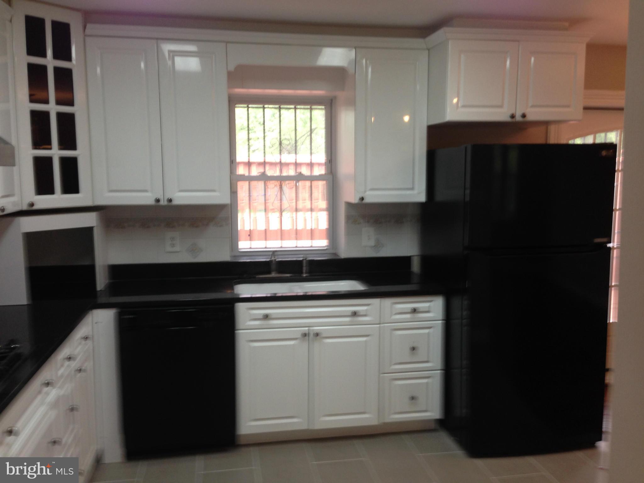9501 Juliette Drive Clinton, MD 20735 - Photo 3 of 27 a kitchen with granite countertop white cabinets and black appliances