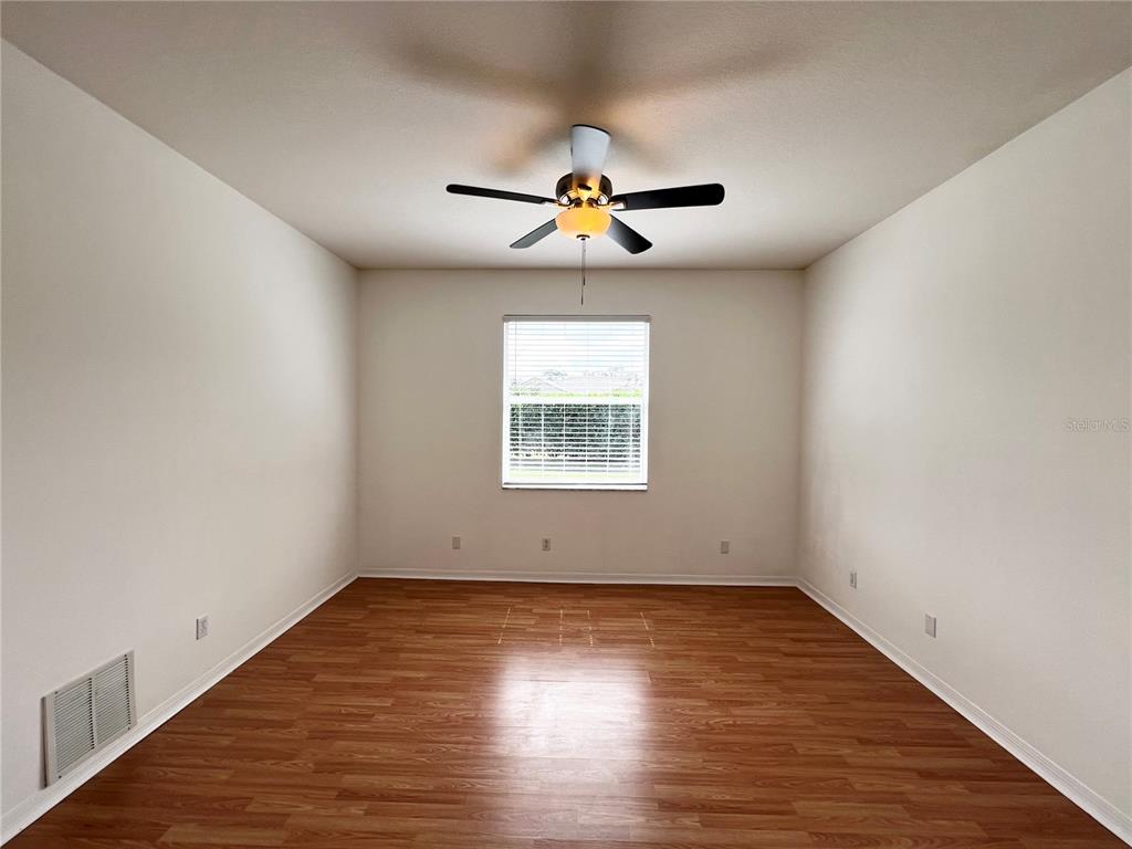 7463 Ridge Road Sarasota, FL 34238 - Photo 11 of 30 an empty room with wooden floor ceiling fan and window