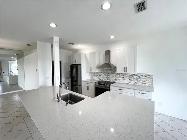 a kitchen with stainless steel appliances granite countertop a sink a stove a refrigerator and a oven