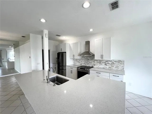 a kitchen with stainless steel appliances granite countertop a sink a stove a refrigerator and a oven