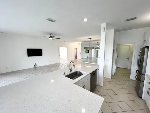 a kitchen with stainless steel appliances a sink a stove a refrigerator and cabinets