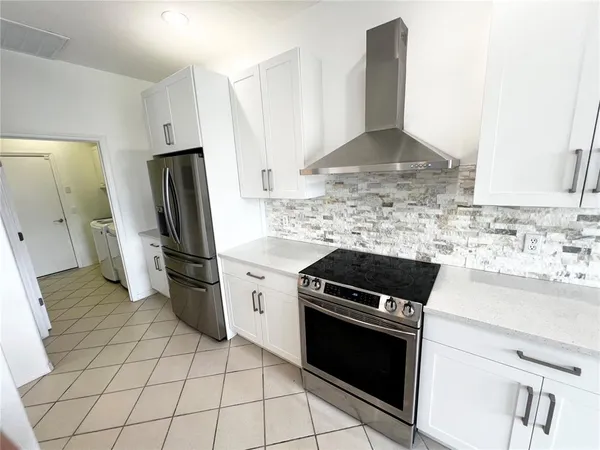 a kitchen with a stove a refrigerator and a sink