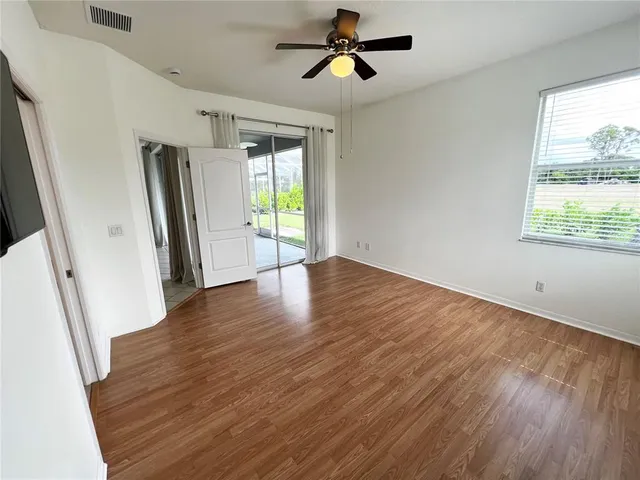 a view of empty room with wooden floor and window