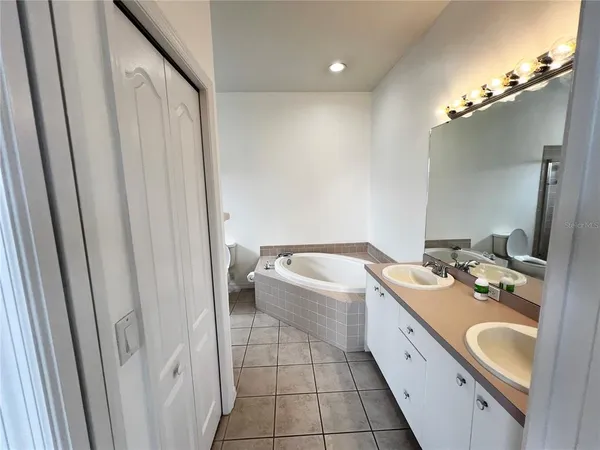 a spacious bathroom with a double vanity sink a mirror and a bathtub