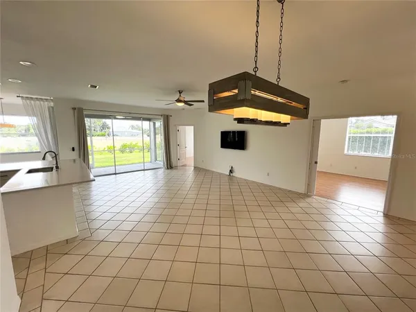 a view of a kitchen with a sink and an empty room