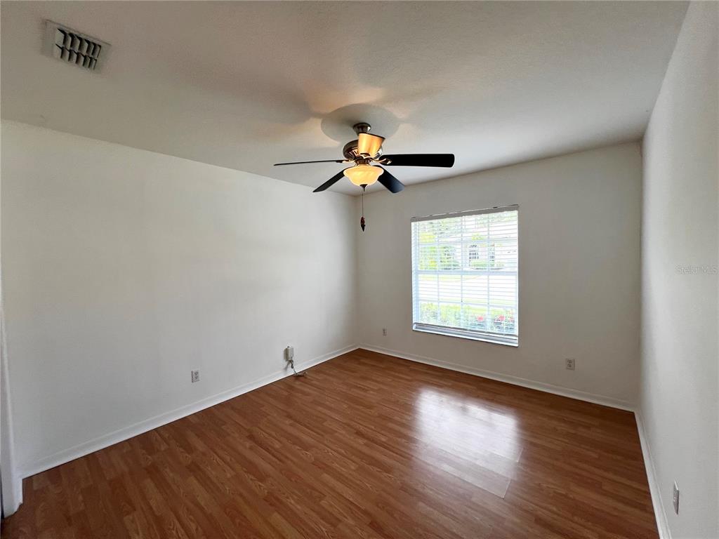 7463 Ridge Road Sarasota, FL 34238 - Photo 7 of 30 a view of an empty room with wooden floor and a window