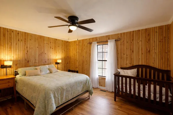 a bedroom with a bed and wooden floor