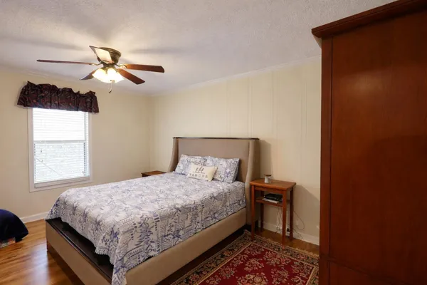 a bedroom with a bed chandelier and a window