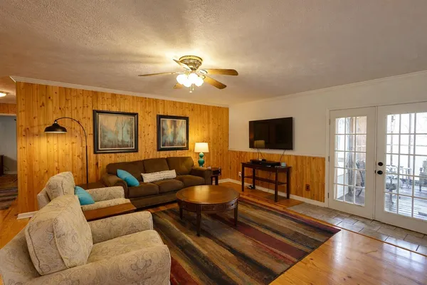 a living room with furniture a flat screen tv and a window