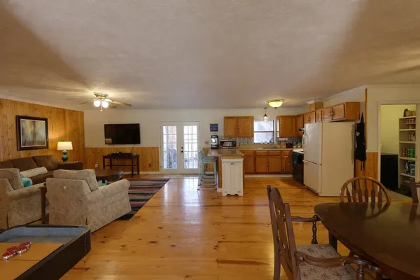 a living room with furniture kitchen view and a refrigerator