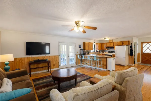 a living room with furniture kitchen view and a flat screen tv