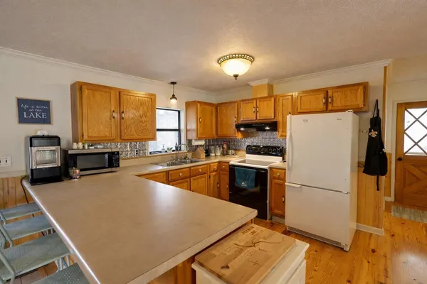 a kitchen with stainless steel appliances a refrigerator sink and wooden floor