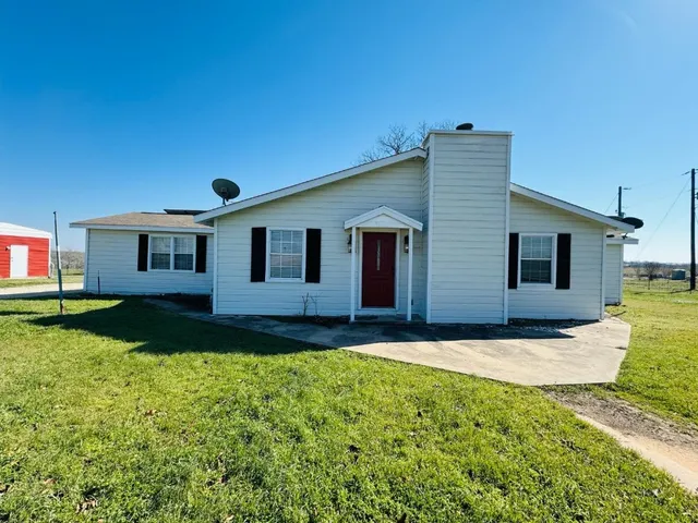 a view of a yard in front of a house with large trees