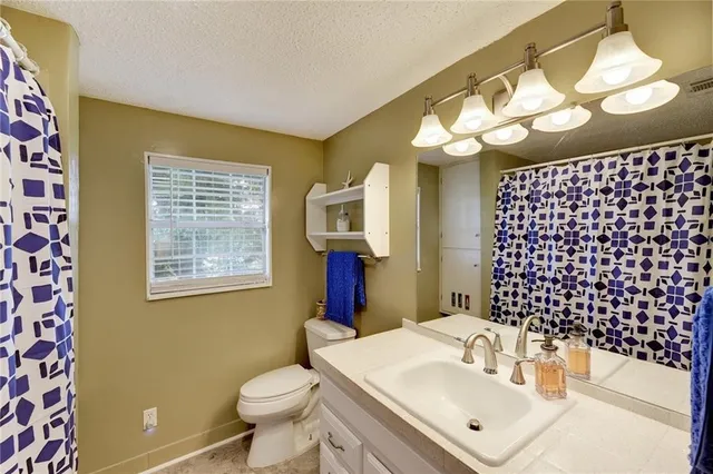 a bathroom with a sink mirror and toilet
