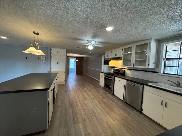 a kitchen with counter top space and wooden floor