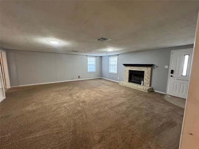 an empty room with fireplace and windows