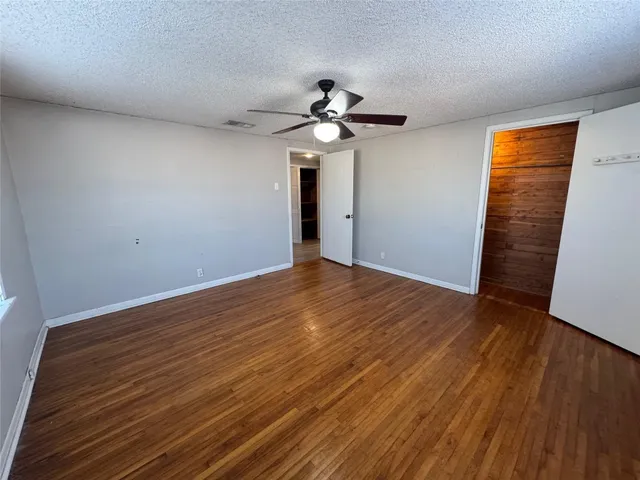 a view of a room with wooden floor and fan