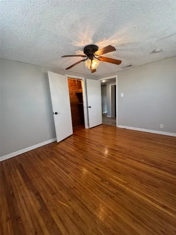 a view of a big room with wooden floor and windows