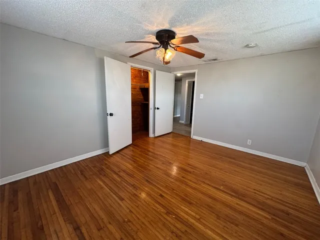 a view of room with wooden floor ceiling fan and window