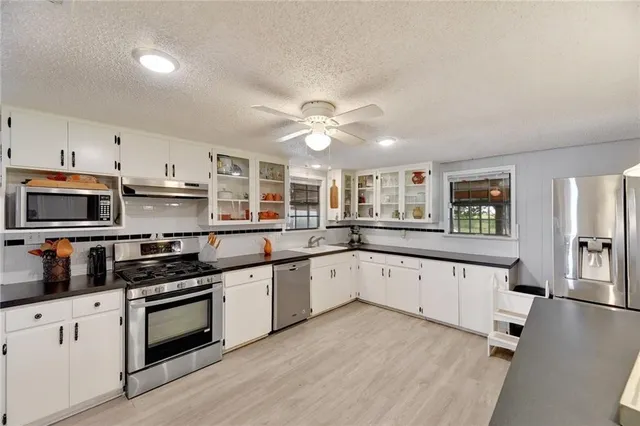 a kitchen with stainless steel appliances granite countertop a stove and cabinets